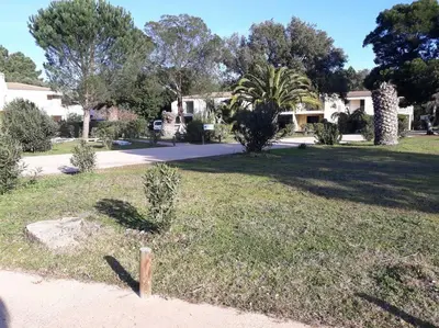 a grassy area with trees and houses in the background at Très joli appartement T3 fraîchement rénové, dans résidence hôtellière in Lecci