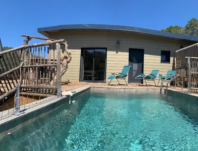 a swimming pool with chairs and a house at CASA JEANATA in Sainte-Lucie de Porto-Vecchio