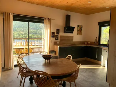a kitchen with a wooden table and chairs and a table at CASA JEANATA in Sainte-Lucie de Porto-Vecchio