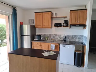 a kitchen with wooden cabinets and a white refrigerator at NOUVEL LOCATION d'un Bel appart T2 climatisé et meublé au RDCh avec piscine dans residence les Melody in Santa-Maria-Poggio