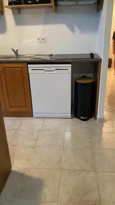 a kitchen with a white dishwasher next to a counter at NOUVEL LOCATION d'un Bel appart T2 climatisé et meublé au RDCh avec piscine dans residence les Melody in Santa-Maria-Poggio