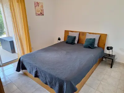 a bedroom with a large bed with blue pillows at NOUVEL LOCATION d'un Bel appart T2 climatisé et meublé au RDCh avec piscine dans residence les Melody in Santa-Maria-Poggio