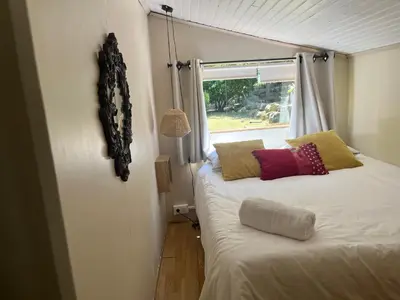 a small bedroom with a bed with a window at L’oléado in Oletta