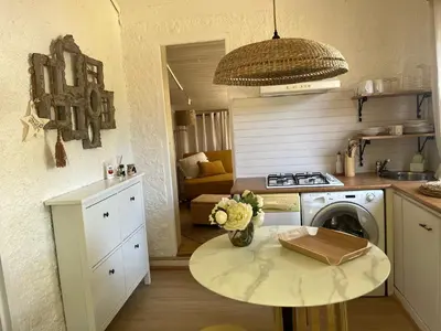 a kitchen with a table and a stove and a washer at L’oléado in Oletta