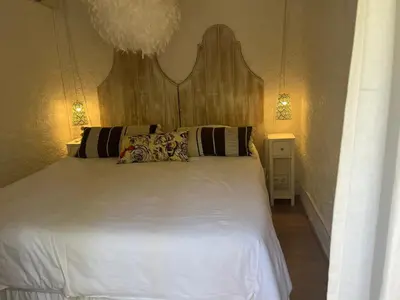 a bedroom with a white bed with two pillows at L’oléado in Oletta