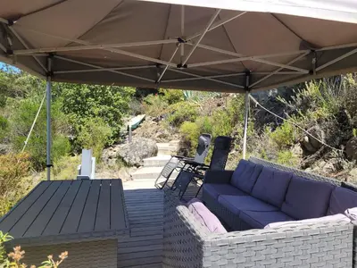 a patio with a couch and a table under an umbrella at Evasion in Ventiseri
