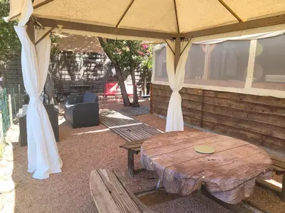 a wooden table under a pavilion with a table and a bench at Evasion in Ventiseri