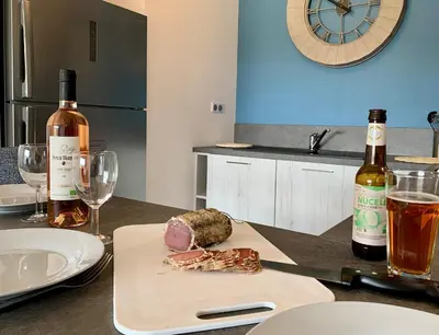 a table with two bottles of wine and a plate of food at Appart T3 4 étoiles 4/6 personnes Porto Vecchio in Porto-Vecchio