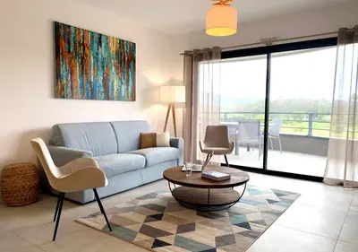 a living room with a couch and a table at Appart T3 4 étoiles 4/6 personnes Porto Vecchio in Porto-Vecchio