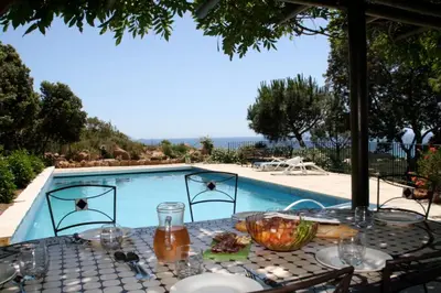 a table with plates of food next to a swimming pool at panopé in Porto-Vecchio