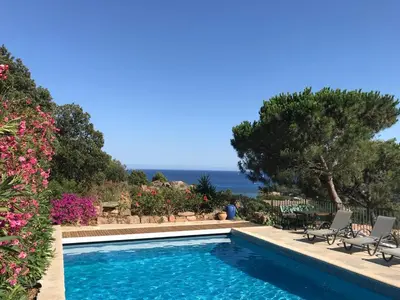 a swimming pool with a view of the ocean at panopé in Porto-Vecchio