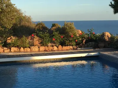 a swimming pool with a view of the ocean at panopé in Porto-Vecchio