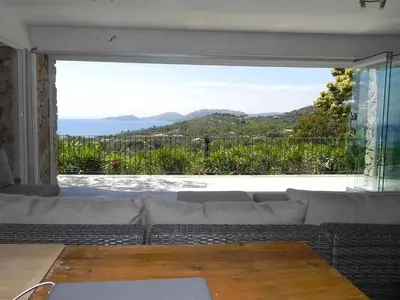 a living room with a couch and a large window at panopé in Porto-Vecchio
