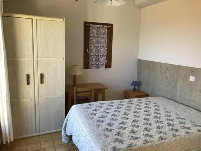 a bedroom with a bed and a table and a window at Galate in Porto-Vecchio