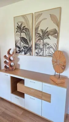 a dresser in a living room with two pictures on the wall at Les Studios de Fiori - Studios et Appartement T2 - Cala Rossa - proche Porto Vecchio in Lecci
