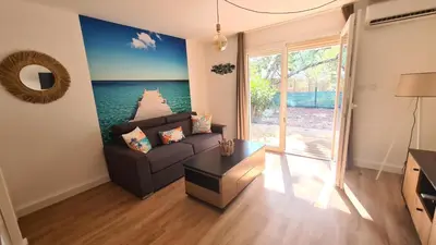 a living room with a couch and a view of a pier at Les Studios de Fiori - Studios et Appartement T2 - Cala Rossa - proche Porto Vecchio in Lecci
