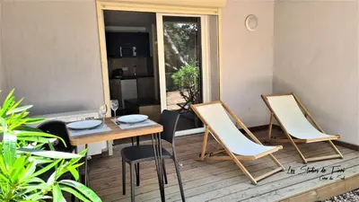a small balcony with a table and two chairs at Les Studios de Fiori - Studios et Appartement T2 - Cala Rossa - proche Porto Vecchio in Lecci