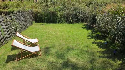 two chairs sitting in the grass in a yard at Les Studios de Fiori - Studios et Appartement T2 - Cala Rossa - proche Porto Vecchio in Lecci