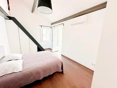 a bedroom with a bed and a large window at Magnifique duplex de 130 m² à Corte (centre ville) in Corte