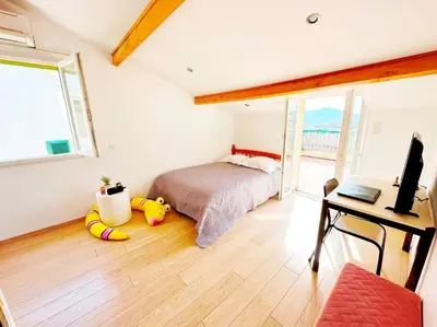 a bedroom with a bed and a desk and a television at Magnifique duplex de 130 m² à Corte (centre ville) in Corte