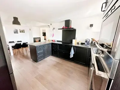 a kitchen with black cabinets and a counter top at Magnifique duplex de 130 m² à Corte (centre ville) in Corte