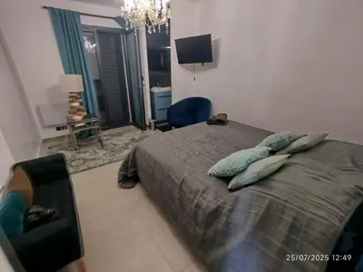 a bedroom with a bed with pillows and a television at VILLA entre mer, montagnes, étangs et rivières in Ventiseri