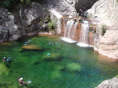 a group of people swimming in a waterfall at VILLA entre mer, montagnes, étangs et rivières in Ventiseri