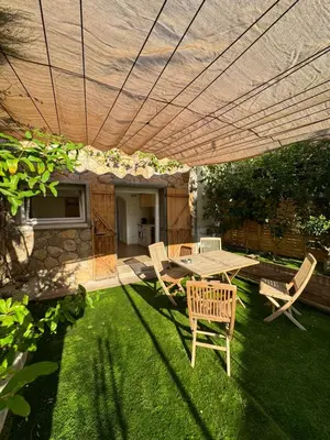 a patio with a table and chairs under an umbrella at Appartement moderne Santa Giulia in Porto-Vecchio