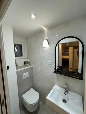 a bathroom with a toilet and a sink and a mirror at Appartement moderne Santa Giulia in Porto-Vecchio