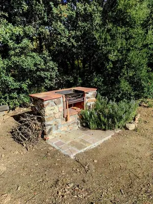 a barbecue grill sitting on top of a stone structure at Magnifique villa entre mer et montagne in Calenzana