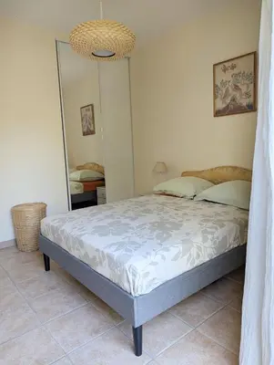 a bedroom with a bed and a large mirror at Magnifique villa entre mer et montagne in Calenzana
