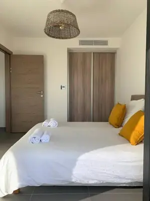 a bedroom with a large white bed with towels on it at Domaine d'Arca Eluard 02- PORTO-VECCHIO - Rez de jardin - 2 à 4 pers in Porto-Vecchio