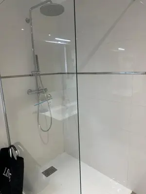 a shower with a glass door and a black bag at Domaine d'Arca Eluard 02- PORTO-VECCHIO - Rez de jardin - 2 à 4 pers in Porto-Vecchio