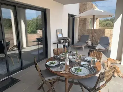 a dining room with a table and chairs at Domaine d'Arca Eluard 02- PORTO-VECCHIO - Rez de jardin - 2 à 4 pers in Porto-Vecchio
