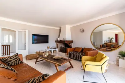 a living room with a couch and a mirror at L'Orangeraie - Maison avec vue pour 12 voyageurs in Grosseto-Prugna