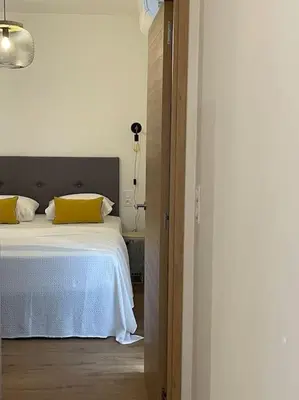 a bedroom with a white bed with yellow pillows at Appartement centre ville Corte (F) in Corte