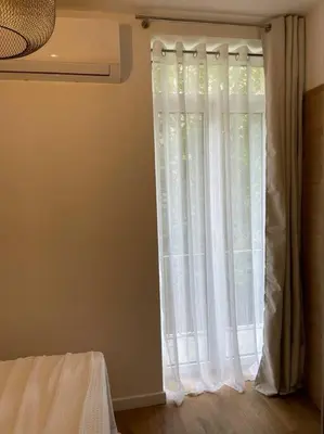 a window with white curtains in a room at Appartement centre ville Corte (F) in Corte