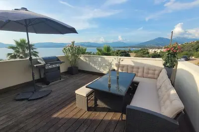 a patio with a table and an umbrella at Appartement terrasse et vue mer in Grosseto-Prugna