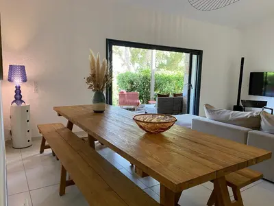 a living room with a wooden table and a couch at Villa de standing et vue mer Porto Vecchio in Porto-Vecchio