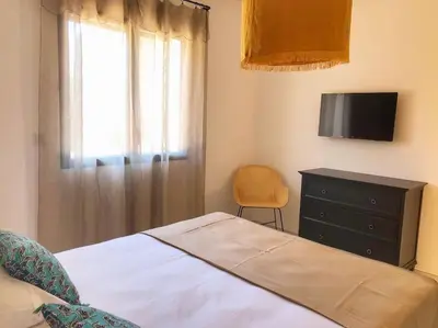 a bedroom with a bed and a dresser and a television at Villa de standing et vue mer Porto Vecchio in Porto-Vecchio