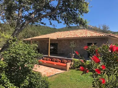 a house with a red couch in the yard at Villa de standing et vue mer Porto Vecchio in Porto-Vecchio