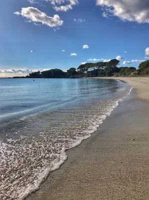 a sandy beach with water and clouds in the sky at Villa de standing et vue mer Porto Vecchio in Porto-Vecchio