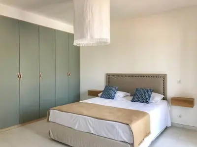 a bedroom with a large bed with blue cabinets at Villa de standing et vue mer Porto Vecchio in Porto-Vecchio