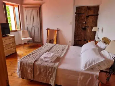 a bedroom with a large bed and a chair at Casadimela in Mela