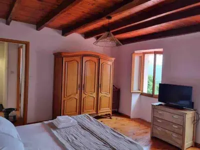 a bedroom with a bed and a cabinet and a tv at Casadimela in Mela