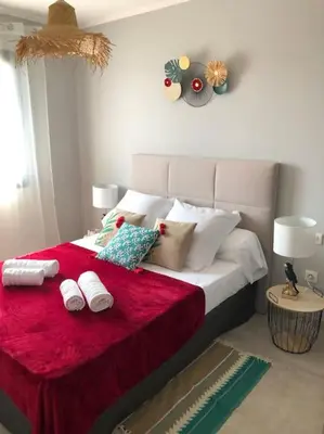 a bedroom with a large bed with a red blanket at Villa neuve avec piscine in Bonifacio