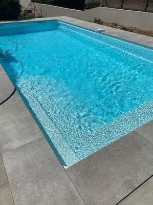 a large blue swimming pool with blue water at Villa neuve avec piscine in Bonifacio