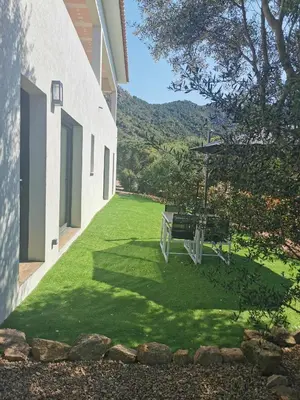 a backyard with a green lawn with a picnic table at Appartement Jardin et Piscine Les anges du maquis location Corse-du-Sud in Conca