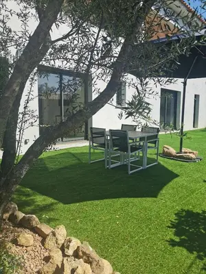 a table and chairs under a tree in a yard at Appartement Jardin et Piscine Les anges du maquis location Corse-du-Sud in Conca