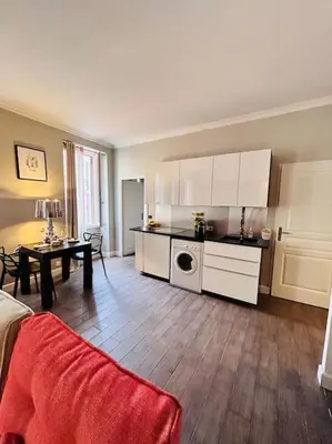 a kitchen with white cabinets and a table in a room at Appartement COSY centre Ajaccio in Ajaccio